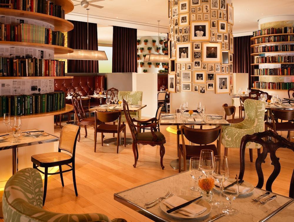 Hotel St Martins Lane Londra Esterno foto The photo depicts an elegant restaurant interior with a modern and inviting atmosphere. The space features a combination of wooden flooring and stylish furniture, including uniquely designed chairs and tables. There are bookshelves lining the walls, 