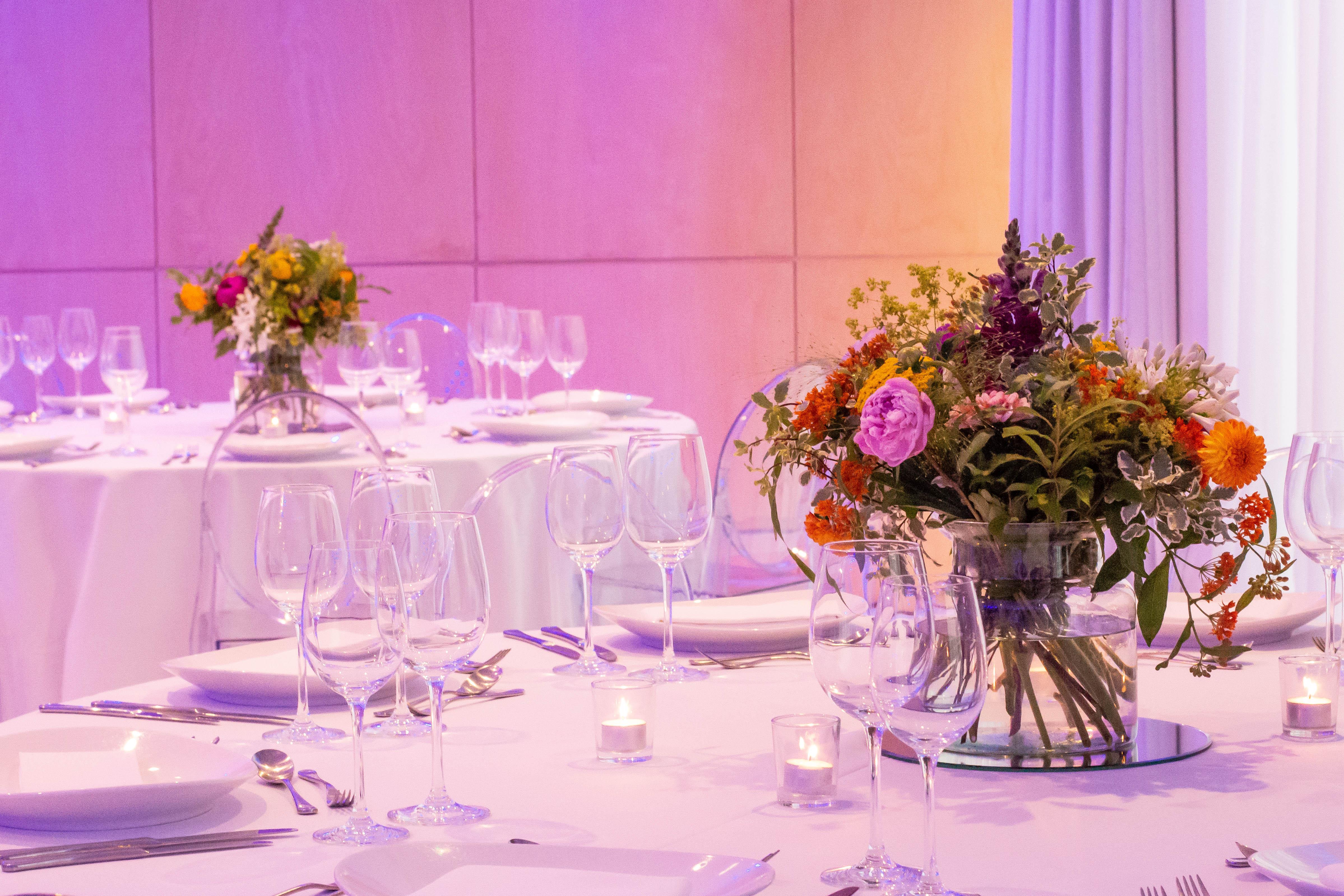 Hotel St Martins Lane Londra Esterno foto The photo shows a beautifully arranged dining setup, likely for an event or celebration. The tables are elegantly dressed with white tablecloths and feature floral centerpieces in clear vases. The bouquets consist of a variety of colorful flowers, ad