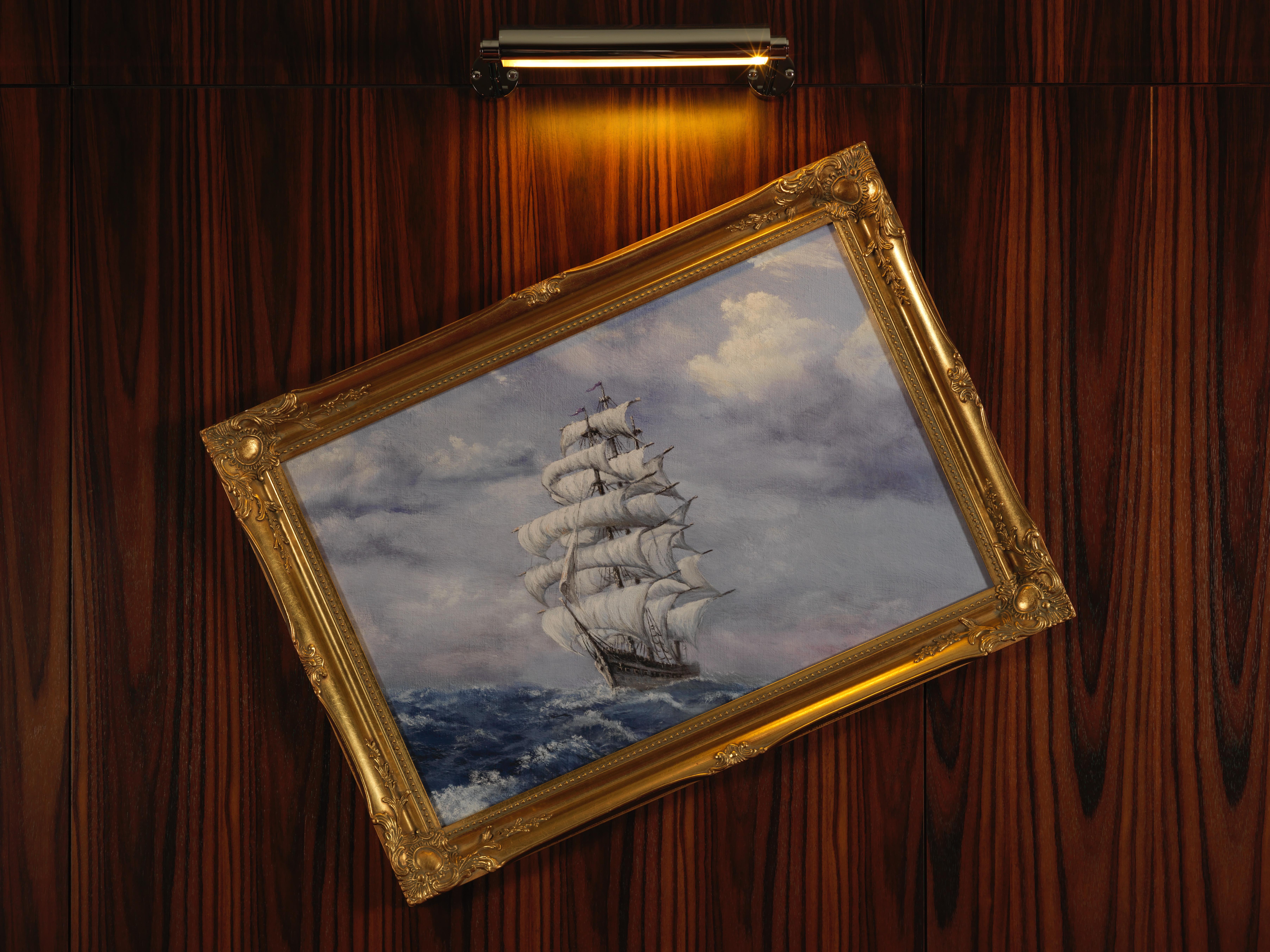 Hotel St Martins Lane Londra Esterno foto The image depicts a painting of a sailing ship with multiple white sails, navigating through turbulent blue waters. The sky above is filled with clouds, adding to the overall dramatic effect of the scene. The painting is housed in an ornate golden fr