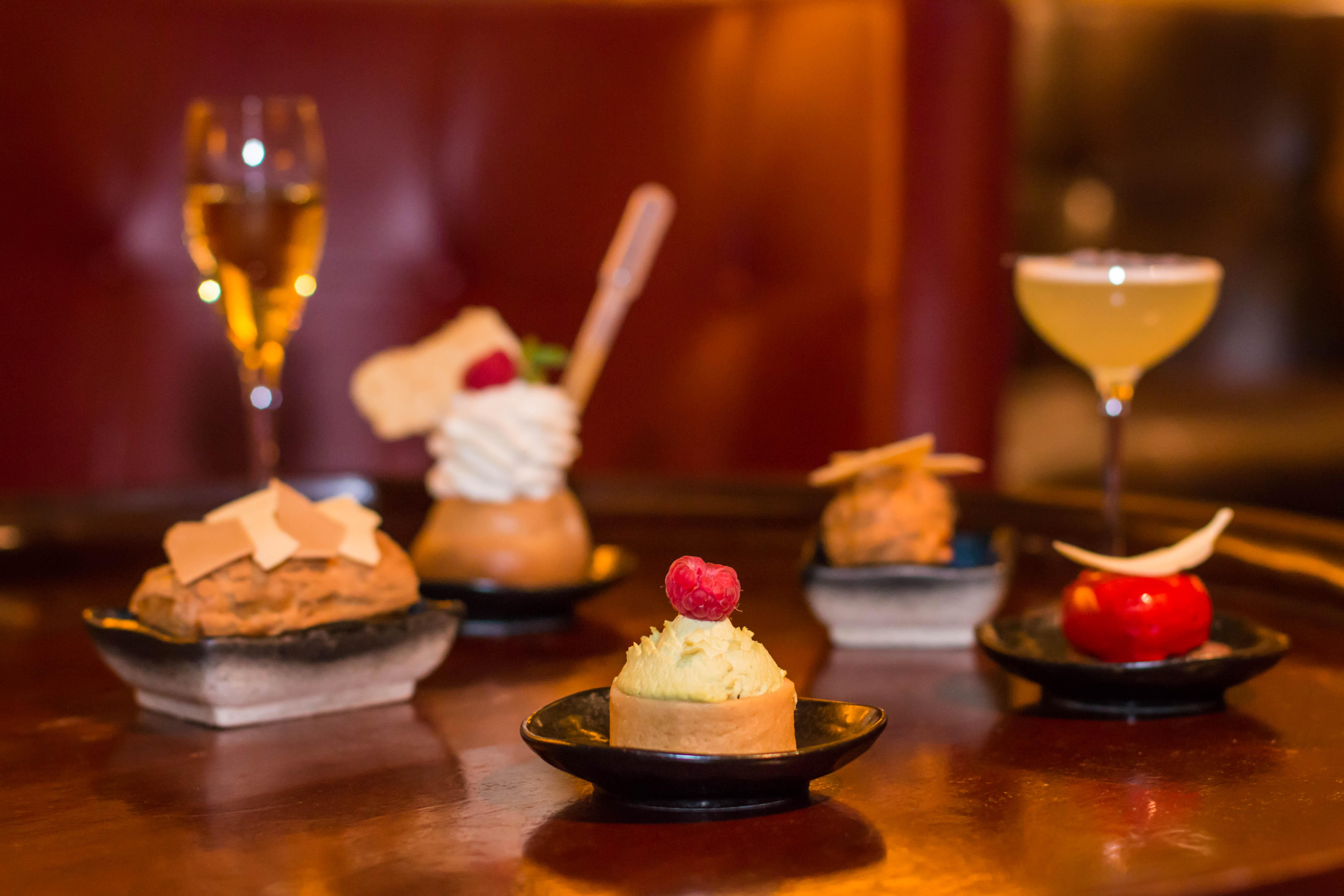 Hotel St Martins Lane Londra Esterno foto The photo showcases a variety of elegantly presented desserts and drinks. In the foreground, there are five small plates, each containing a different dessert. The desserts include a creamy cake topped with a raspberry, a small pastry with a swirl of 