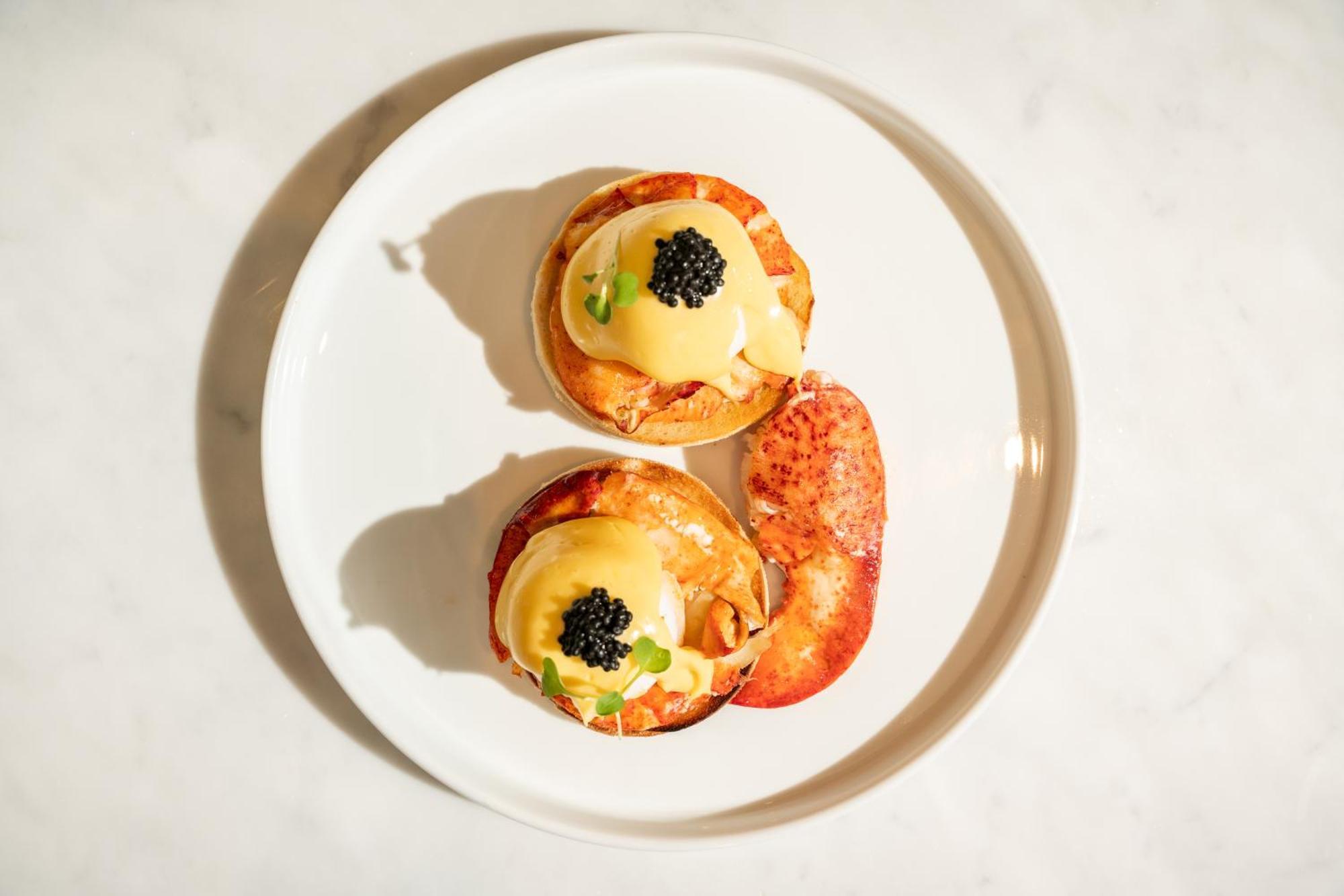 Hotel St Martins Lane Londra Esterno foto The photo shows a plate with two servings of a dish that appears to be eggs Benedict. Each serving consists of a toasted English muffin topped with poached eggs, creamy hollandaise sauce, and garnished with black caviar and possibly some green onions