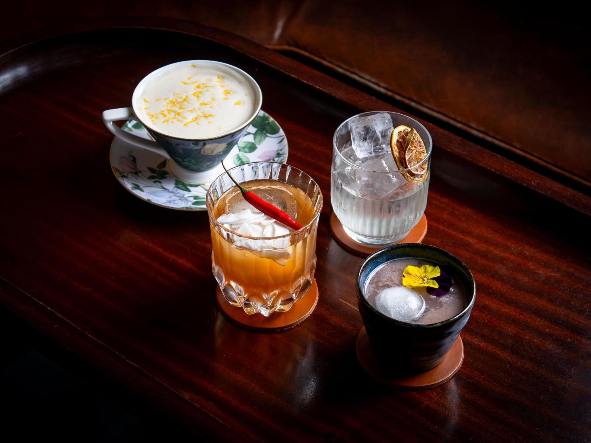 Hotel St Martins Lane Londra Esterno foto The photo features a selection of four different drinks arranged on a wooden surface. 

1. On the left, there is a delicate cup with a floral design, containing a creamy beverage topped with what appears to be shavings or sprinkles, possibly coconut 