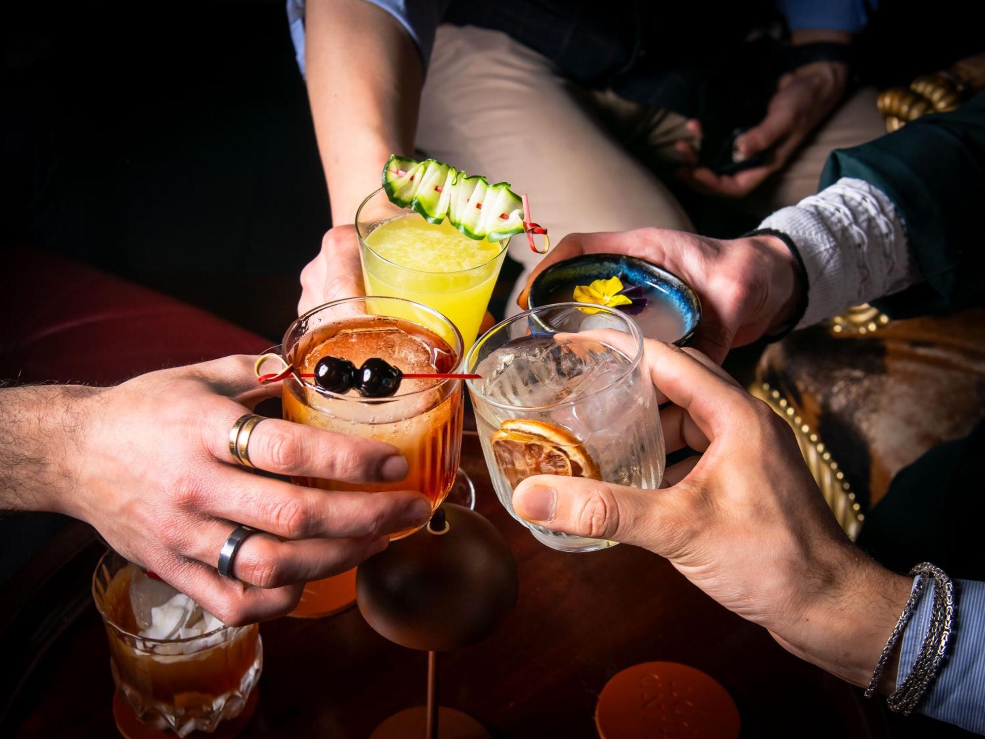 Hotel St Martins Lane Londra Esterno foto The photo features a group of hands holding different colorful cocktails, suggesting a celebratory atmosphere. Each drink has distinct garnishes: one has a cucumber slice, another displays a flower, and others feature fruits and decorative elements. 
