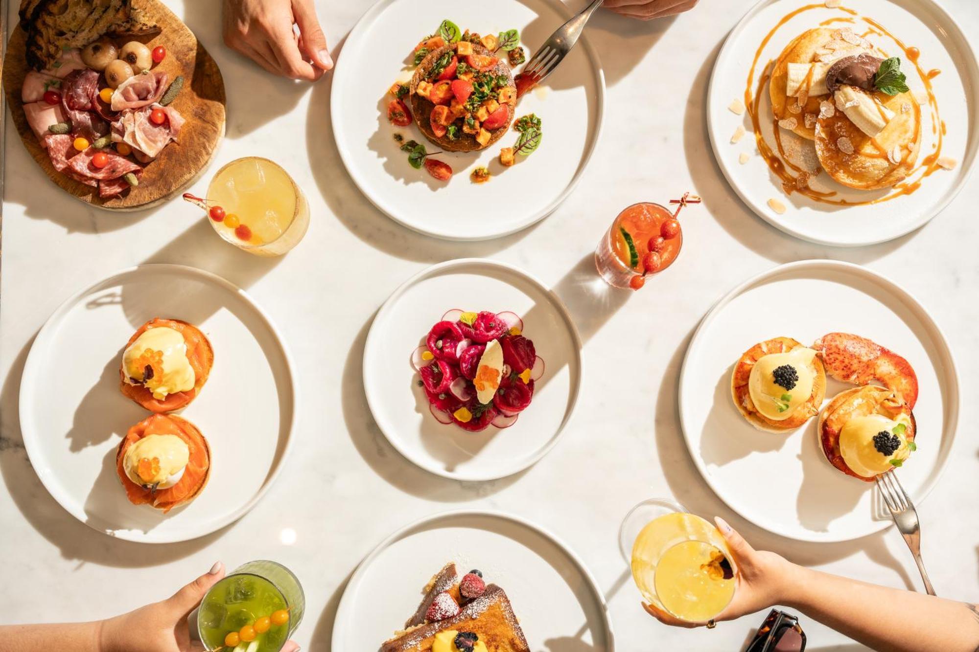 Hotel St Martins Lane Londra Esterno foto The photo showcases a vibrant spread of food arranged on a table. There are several white plates displaying a variety of dishes. 

1. **Savory Dishes**: One plate features a colorful salad with tomatoes and greens. Another looks like a decadent dish,
